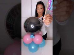 a woman is holding balloons in front of her face and taking a selfie with the camera