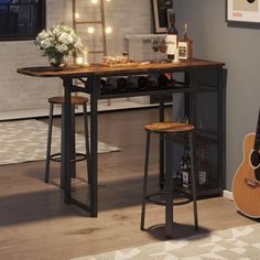 a table with two stools and a guitar