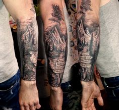 two men with tattoos on their arms are holding hands in front of each other,