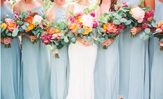 a group of women standing next to each other holding bouquets