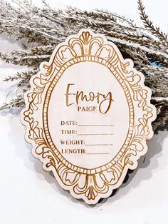 a wooden plaque with the words fancy in gold lettering on it, sitting next to some dry grass