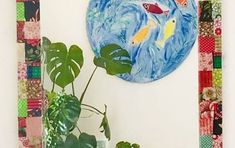 a potted plant sitting in front of a painting on the wall