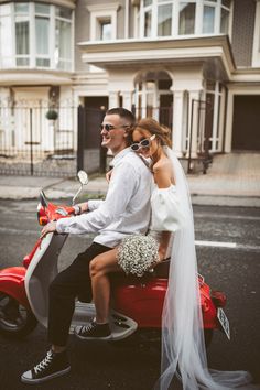 a bride and groom are riding on a scooter