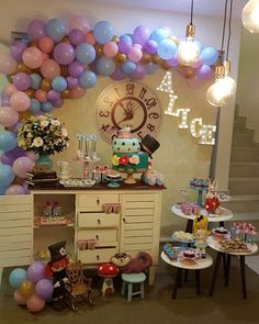 a room filled with lots of balloons and decorations on the wall next to a dresser