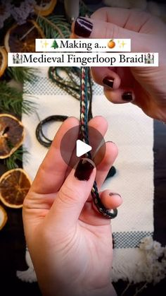 a person is holding a metal ring in their hand and some oranges are on the table