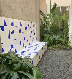 a white and blue bench sitting in the middle of a garden next to a building