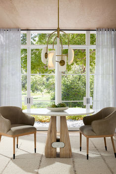 a dining room table with two chairs and a chandelier hanging from the ceiling