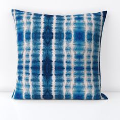 a blue and white pillow sitting on top of a table