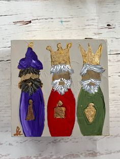 three different colored wine bottles with crowns on them