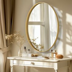 a white table with a mirror and bottles on top of it next to a window