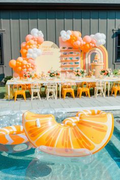 an inflatable orange float is sitting on the edge of a swimming pool with decorations