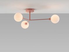 an overhead light fixture with three globes on the bottom and four lights above it