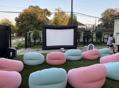 large inflatable chairs are set up on the lawn for an outdoor movie party