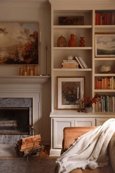 a living room filled with furniture and a fire place in front of a book shelf