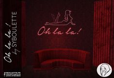 a red couch sitting in front of a wall with the word oh la la on it