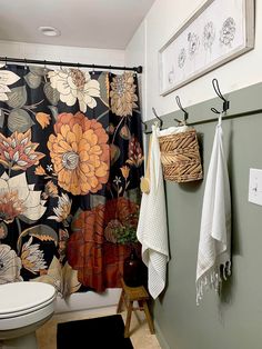 a bathroom with floral shower curtain and rug