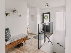 an entryway with a bench and stairs leading up to the second floor in a home