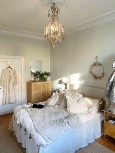 a bed room with a neatly made bed and a chandelier