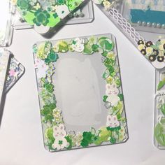 several different items are arranged on a table with white and green accents, including an empty photo frame