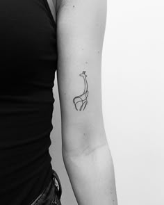 a black and white photo of a woman's arm with a giraffe tattoo on it