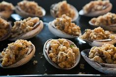 several open oysters are sitting on a baking sheet with some crumbs in them