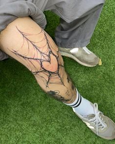 a man with a spider web tattoo on his leg