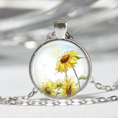 a glass pendant with sunflowers painted on it