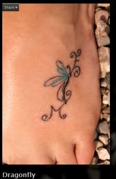 a foot with a small dragon tattoo on it's left side and the word love written