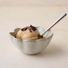 a scoop of ice cream in a bowl with chocolate shavings on the top