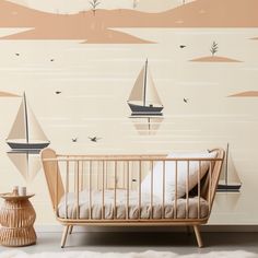 a baby's crib in front of a wall with sailboats on it