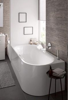 a large white bath tub sitting next to a window