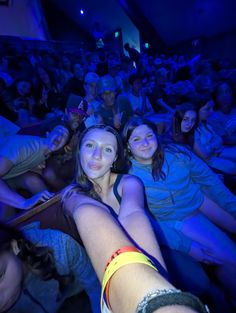 a group of people sitting in the middle of a room with blue lights on them