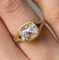 a close up of a person's hand with a diamond ring on their finger