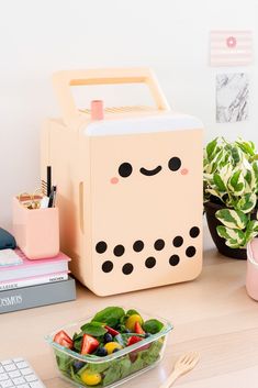 a lunch box sitting on top of a desk next to a keyboard