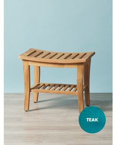 a wooden bench sitting on top of a hard wood floor next to a blue wall