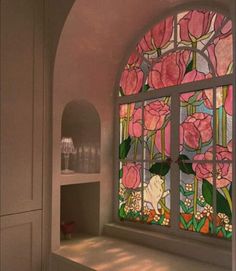 a large stained glass window sitting inside of a white wall next to a shelf with vases on it