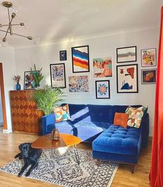 a living room with blue couches and pictures on the wall above it's coffee table