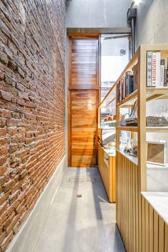 a brick wall and wooden shelves in a room