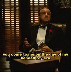 a man in a tuxedo sitting at a desk