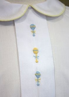 a white shirt with blue and yellow designs on the collar, along with an embroidered tie