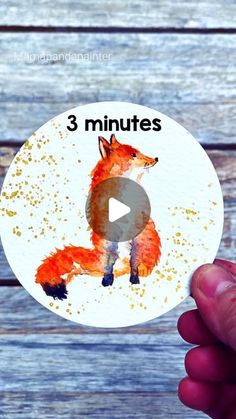 a hand holding up a sticker with an image of a red fox on it