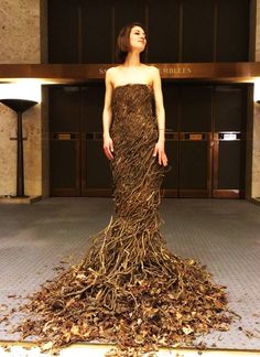 a woman standing in front of a pile of leaves