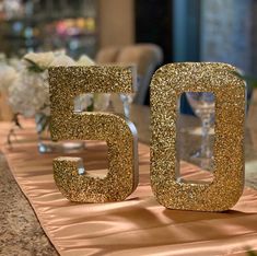 the table is set up with gold glitter numbers