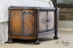 a bed with a white comforter and wooden furniture on it's side table