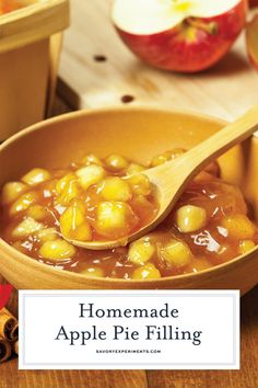 a wooden spoon filled with apple pie filling on top of a table next to apples