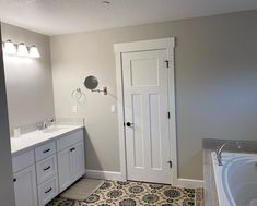 a bathroom with a bathtub, sink and mirror next to a doorway that leads to another room