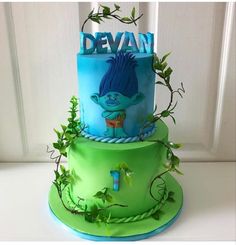 there is a green cake with blue frosting on the top and bottom tiers