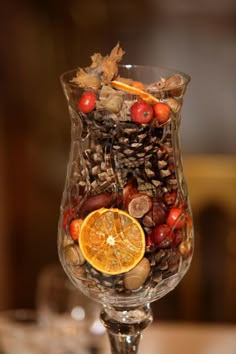 a glass filled with fruit and nuts on top of a table