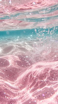 the water is pink and blue with white bubbles on it's surface, as seen from below