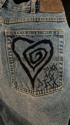 the back pocket of someone's jean pants with graffiti on it and a heart